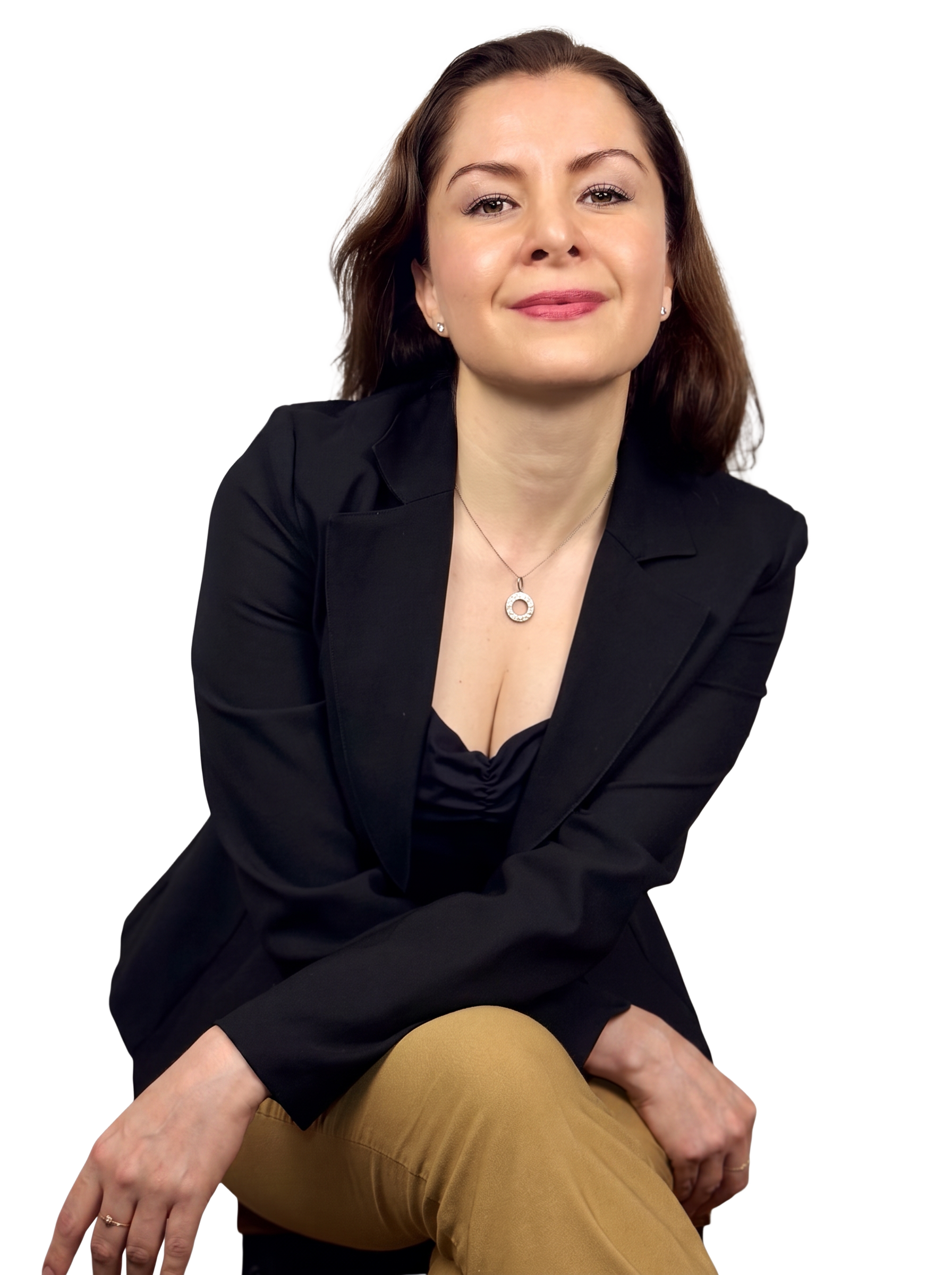 Wendy Lechuga, artist visa strategist, seated in a black blazer and camel trousers, smiling toward the camera.